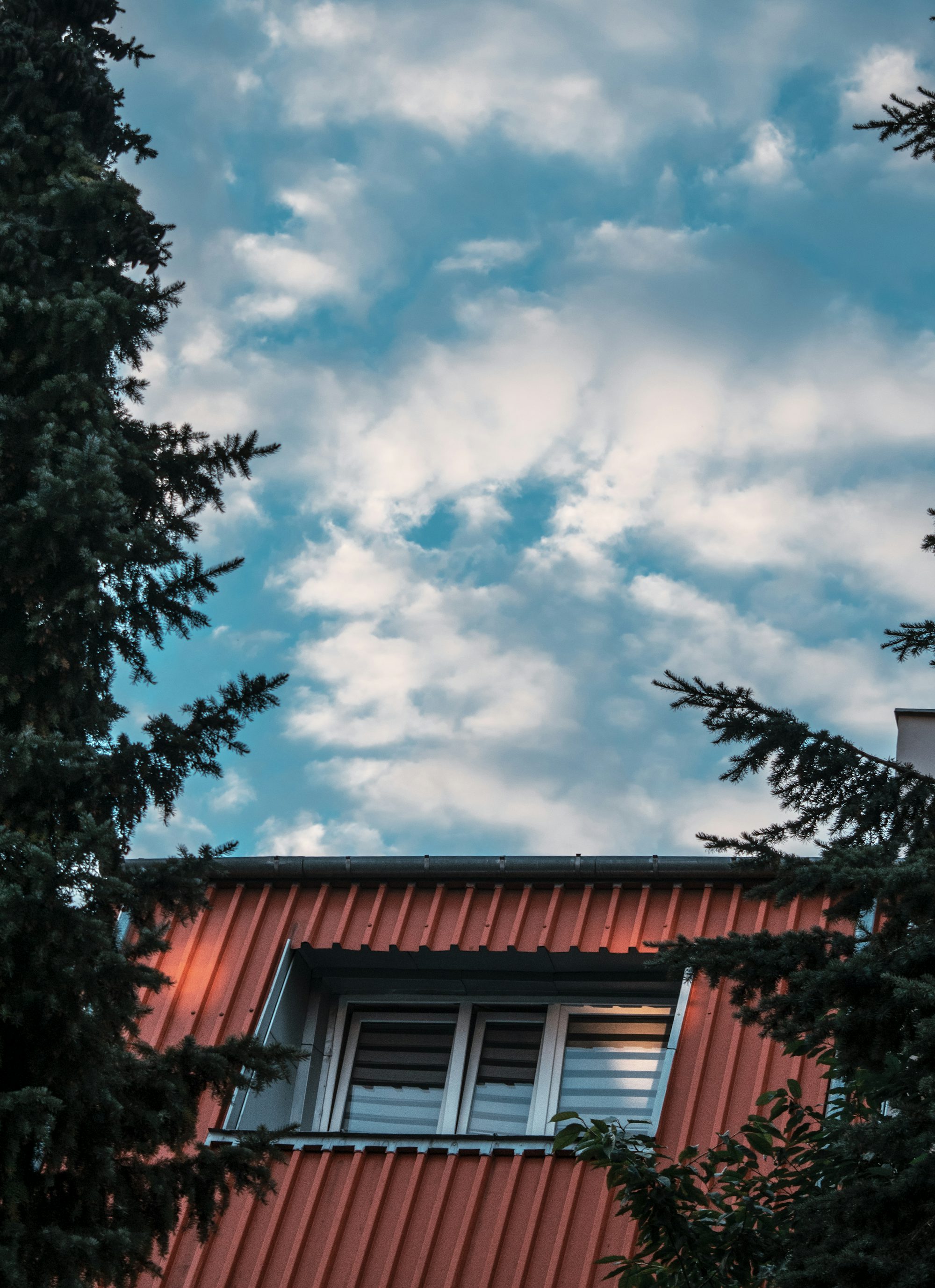 a red house with trees in the back