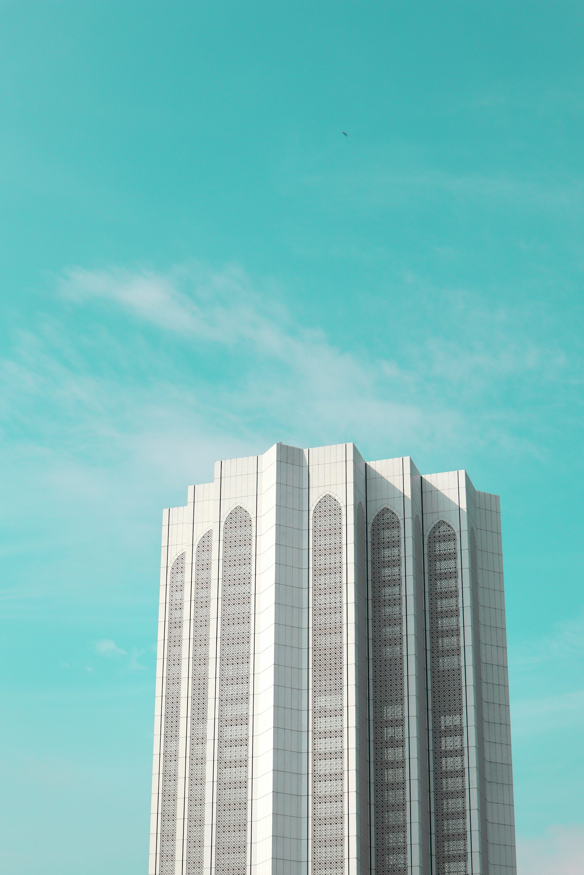 a tall white building with a sky background