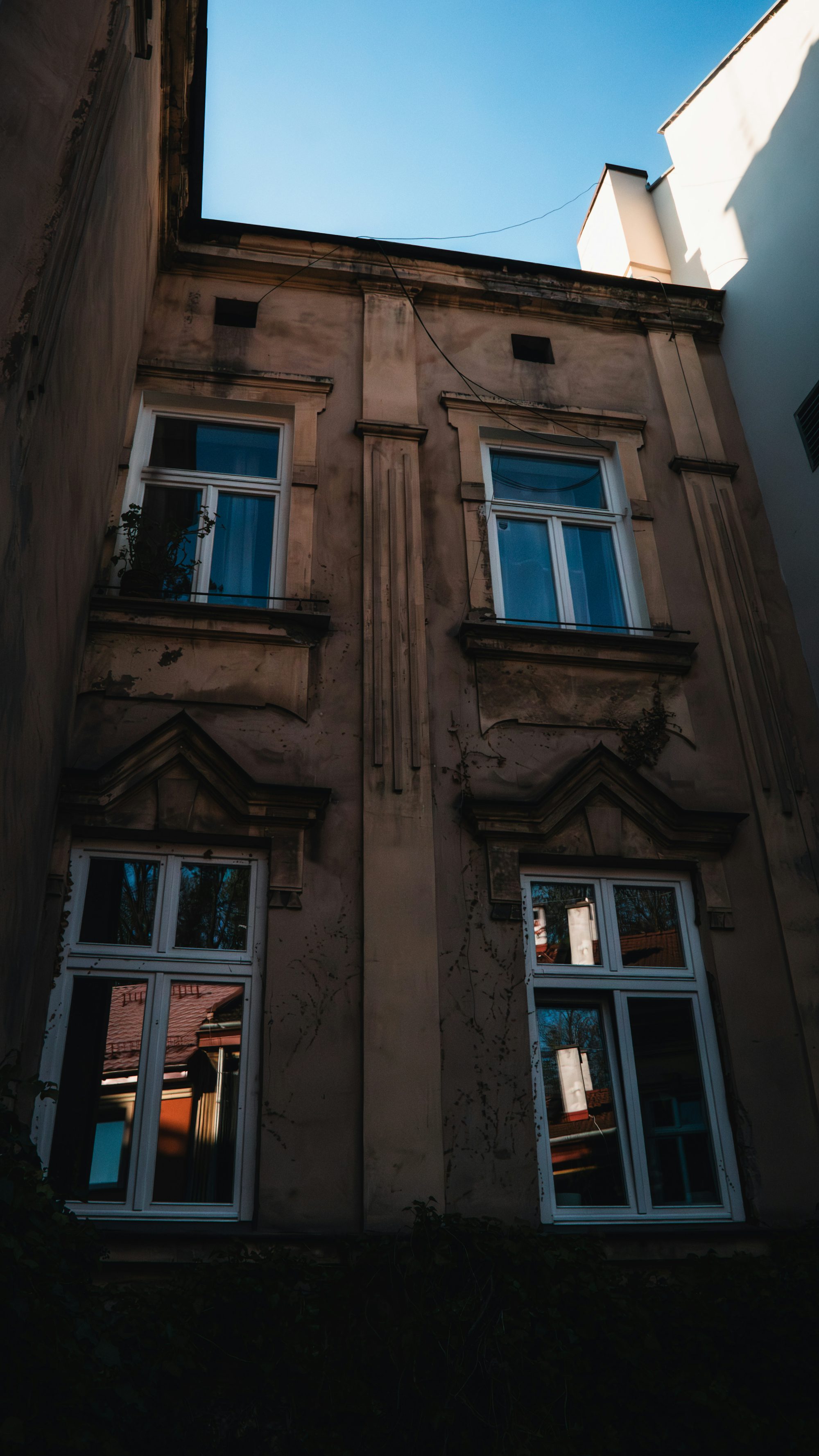 a tall building with windows and a sky background